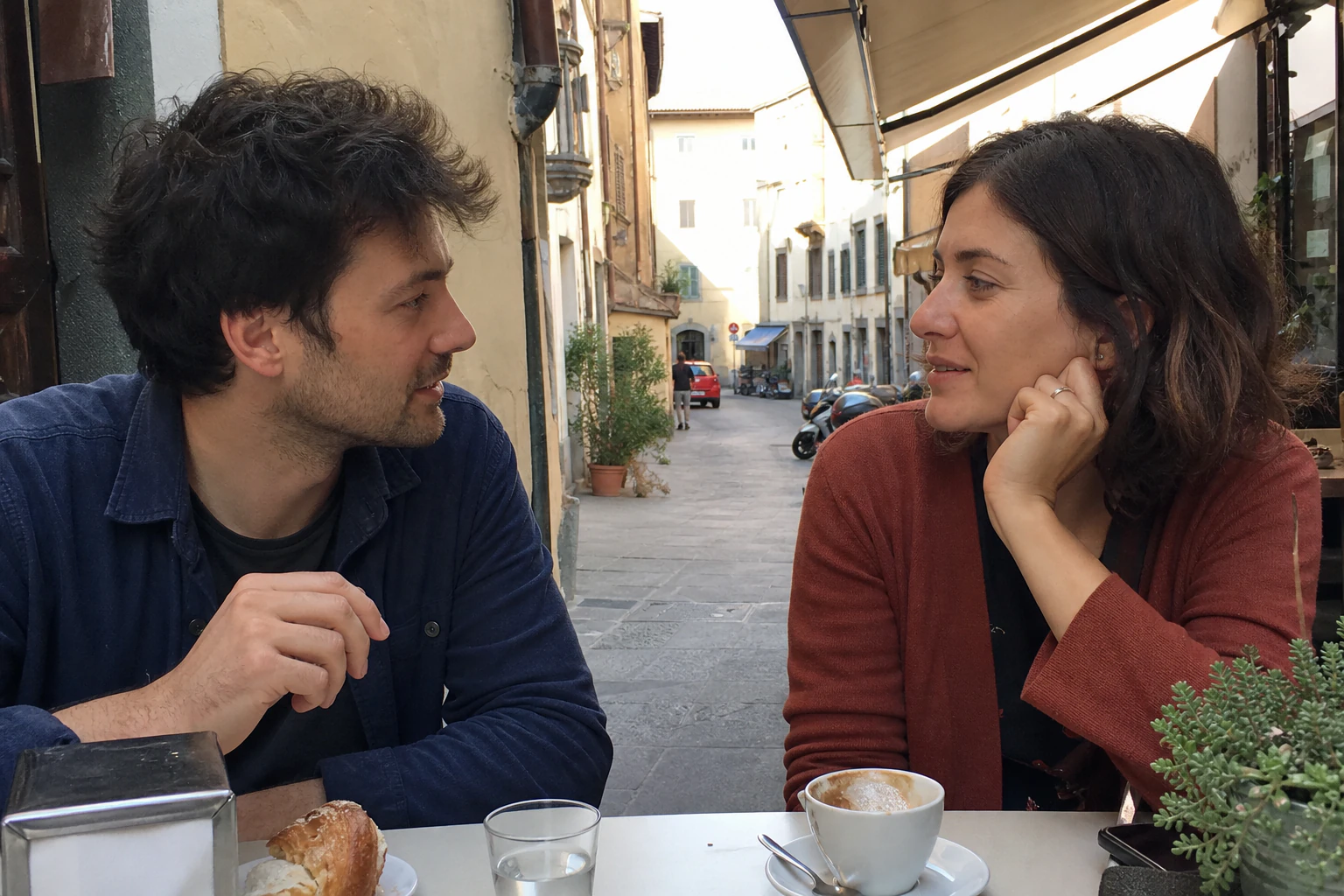 Source photograph of a couple sitting together at a cafe table.
